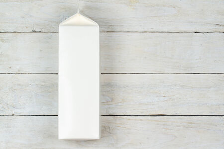 Blank cardboard milk pack on wooden tableの写真素材