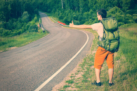 Man with backpack hitchhiking. Toned imageの写真素材