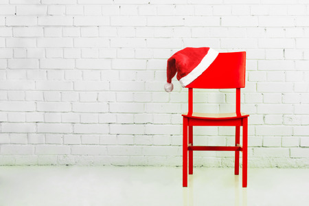 Santa hat on a chair against brick wall. Christmas conceptの写真素材