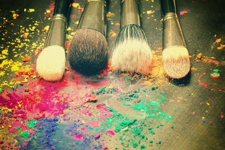 Makeup brushes on a background with colorful powder. Toned imageの写真素材