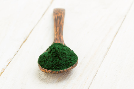 Organic spirulina algae powder in wooden spoonの写真素材