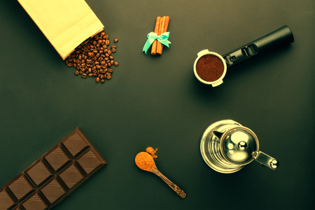 Coffee espresso in a holder, coffee-beans, bar of chocolate, cinnamon, coffee-potの写真素材