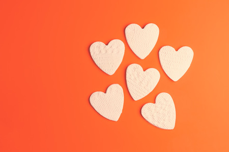 Handmade clay hearts against orange backgroundの写真素材
