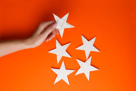 Female hand holding little stars made of pottery clayの写真素材