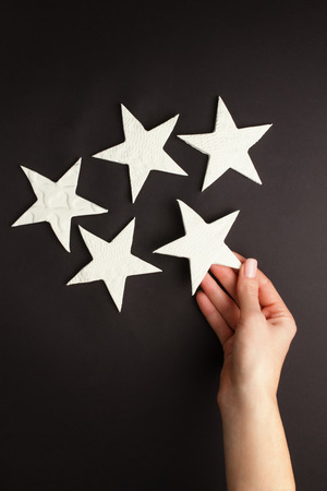 Female hands holding little stars made of pottery clayの写真素材