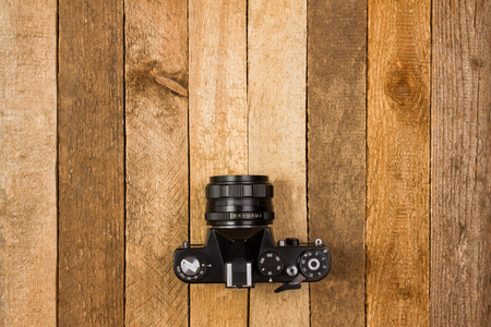Vintage film camera on tiled wooden background