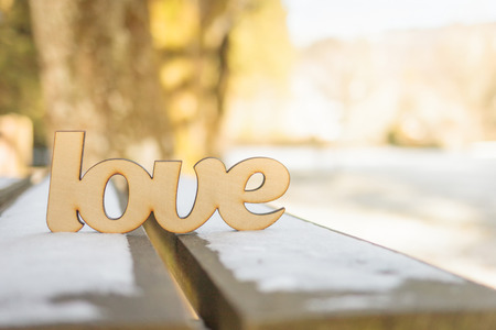 Wooden love sign on wooden bench outdoor. Winter weather concept.の写真素材