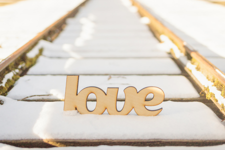 Close-up of love sign on old rails in snow. Relationship conceptの写真素材