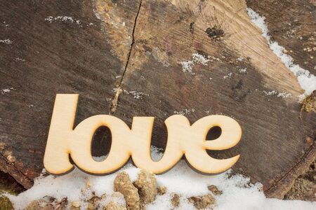 Abstract wooden love sign on wooden texture with snowの写真素材