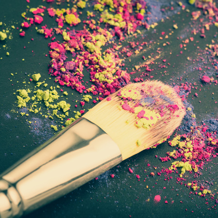 Close-up of make-up brush on colorful eyeshadow background. Macro photo of makeup brushの写真素材