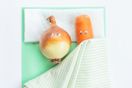 Carrot with leek lying together in bed. Top view. Cute food conceptの写真素材