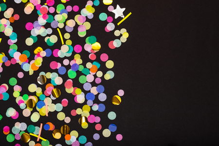 Colorful confetti scattered on black background with copy spaceの写真素材