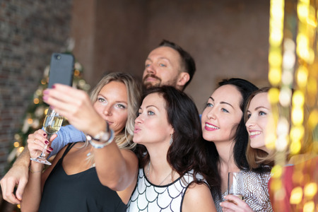Fellow colleagues taking selfie together at New Years party at officeの写真素材