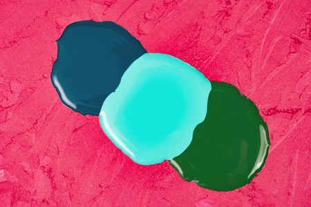 Liquid nail varnish drops on a red lipstick backgroundの写真素材