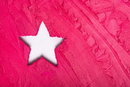Lipstick texture with a hole in a shape of star. Glamour background with a space for your copy
