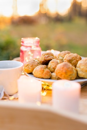 Delicious cookies with candles on a wooden tray outdoors. Coffee seting outdoorsの写真素材
