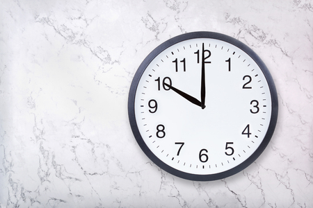 Wall clock show ten oclock on white marble texture. Office clock show 10pm or 10am on marble backgroundの写真素材