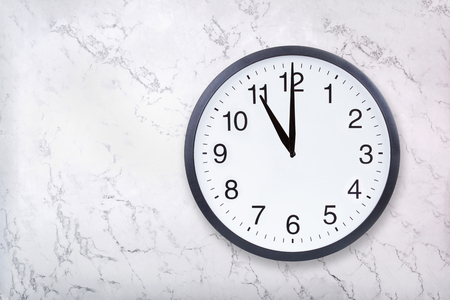 Wall clock show eleven oclock on white marble texture. Office clock show 11pm or 11am on marble backgroundの写真素材
