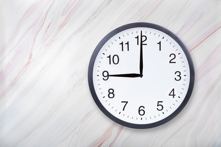 Wall clock show nine oclock on marble texture. Office clock show 9pm or 9am on marble texture with natural patternの写真素材