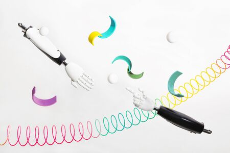 Abstract robot hands with colorful items on white background. Game design creative concept. Virtual...