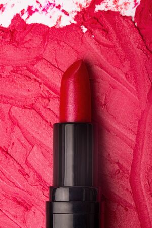 Close-up image of red lipstick on a smudged lipstick background. Top view. Flat layの写真素材