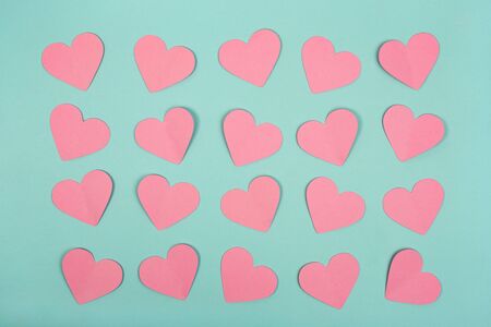 Flat lay of pink paper heart cards on blue background. Abstract hearts paper cut out concept.の写真素材