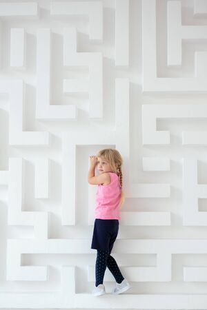 Little girl climbing on a labyrinth wall. Creative conceptの写真素材