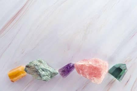 Crystal stones on a marble background. Flat lay of colorful gemstones and crystals with copy spaceの写真素材