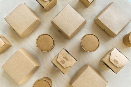 Flat lay of different dispasable paper boxes and cups on wooden texture.の写真素材