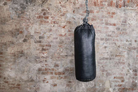 Black punching bag with grunge brick wall with blank spaceの写真素材
