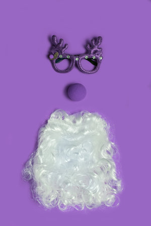 Christmas concept with funny purple glasses and Santa beard on ultra violet background. Funny face...