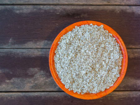 rolled oats in a bowl on wooden tableの写真素材