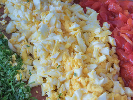 parsley boiled egg and fried red pepper all cut into pieces close up view