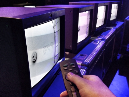 Hand holding remote control with TV set