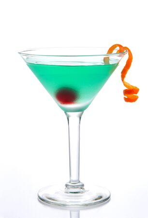 Tropical Martini cocktail with vodka, blue curacao, white cranberry juice, lemon liquor, maraschino cherry and orange spiral isolated on a white backgroundの写真素材