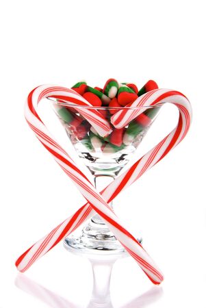 Martini Glass with christmas and new year candies, heart of candy canes isolated on a white backgroundの写真素材