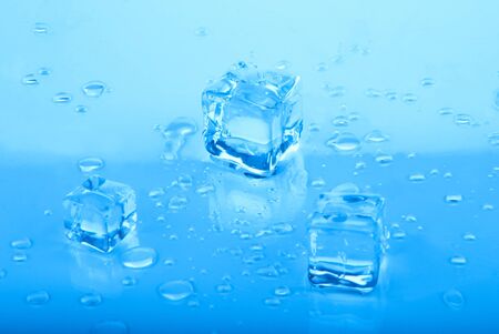 three blue Ice cubes with water dropsの写真素材