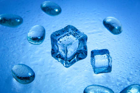 Ice cubes with  pure water drops  isolated on the blue backgroundの写真素材