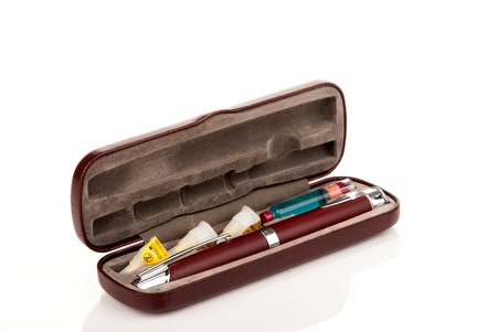 Insulin syringe injection pen in the case with extra insulin flask and three needles inside isolated on a white backgroundの写真素材