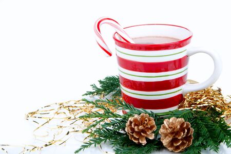 Christmas cups with Hot hot chocolate, tea, cocoa, candy cane decorated with fir branch and two pine cones isolated on a white backgroundの写真素材