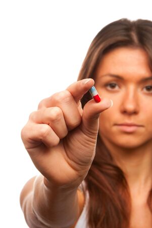 Young woman holds red and blue aspirin pill capsule in right hand offering it to the patient isolated on a white background. The most popular medical imageの写真素材