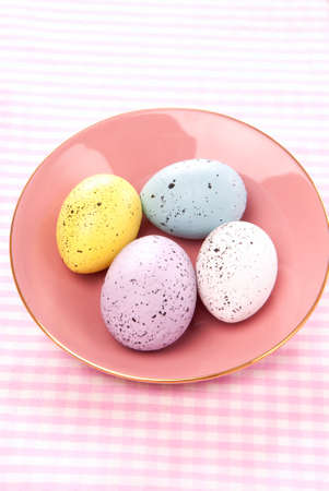 Easter Painted Colorful eggs on a saucer for sunday morning on a pastel color backgroundの写真素材
