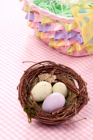 Easter Painted Colorful eggs in birds nest  for sunday morning on a pastel color backgroundの写真素材