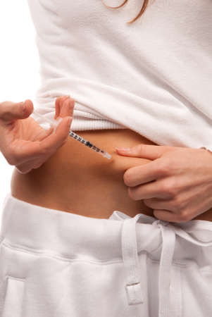First type Diabetes patient giving herself abdomen insulin injection shot by single use syringe with dose of lantus isolated on a white backgroundの写真素材