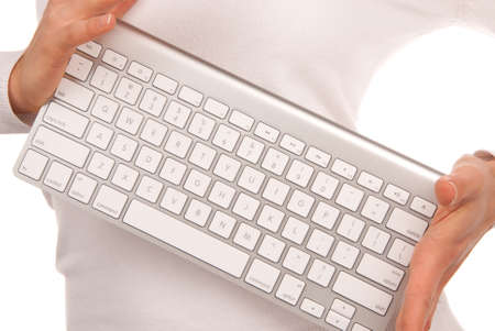 Hands holding white remote laptop keyboard modern and stylish that can be connected to PC computer by bluetooth isolated on white backgroundの写真素材