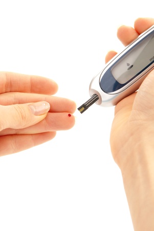 Measurement of glucose level blood test using ultra mini glucometer and small drop of blood from finger and test strips from diabetes patient isolated on a white background. の写真素材