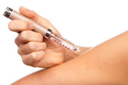 Doctor hand injecting medical insulin syringe pen making humalog injection in arml isolated on a white backgroundの写真素材
