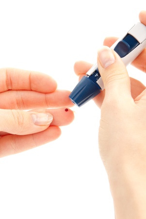 Diabetic lancet in hand prick finger to make punctures to obtain small blood specimens for blood glucose, hemoglobin level test using glucometer isolated on a white backgroundの写真素材