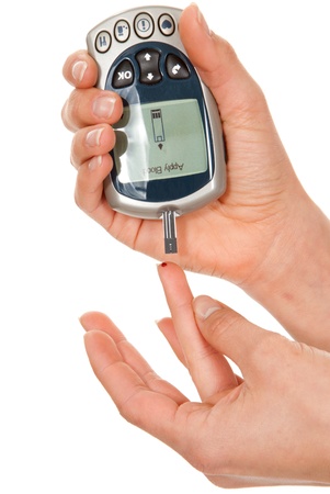Diabetes patient poked finger to measure a glucose blood level test by new smart glucometer isolated on a white backgroundの写真素材