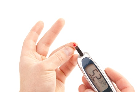 Dependent first type Diabetic patient measuring glucose level blood test using ultra mini glucometer and small drop of blood from finger and test strips isolated on a white backgroundの写真素材